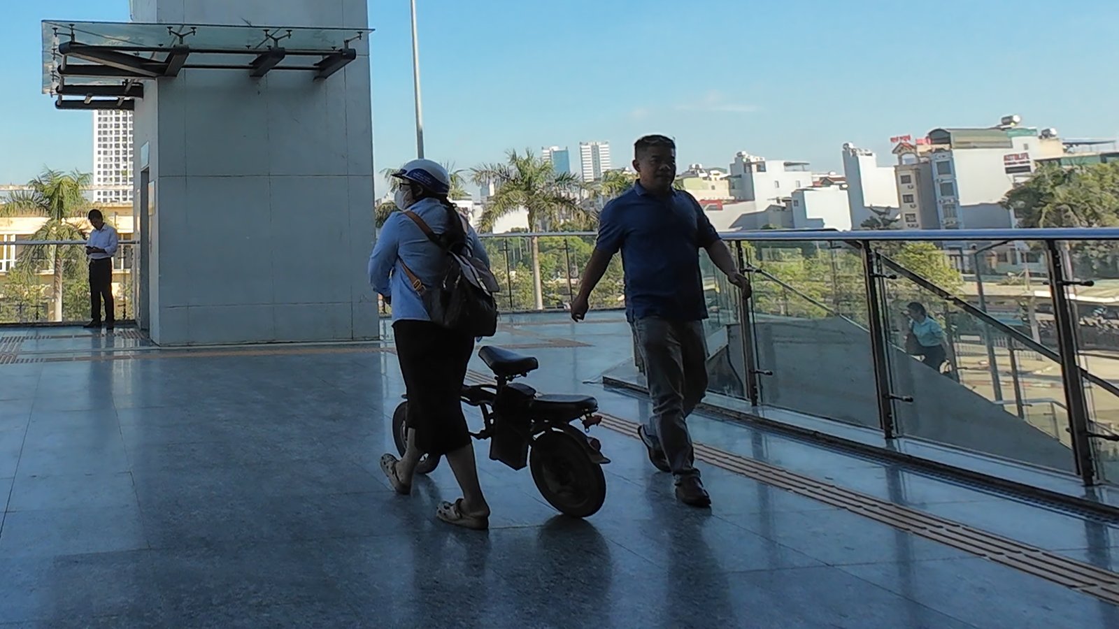 Người dắt xe đạp gấp trên cầu đi bộ từ bến xe sang ga metro Yên Nghĩa