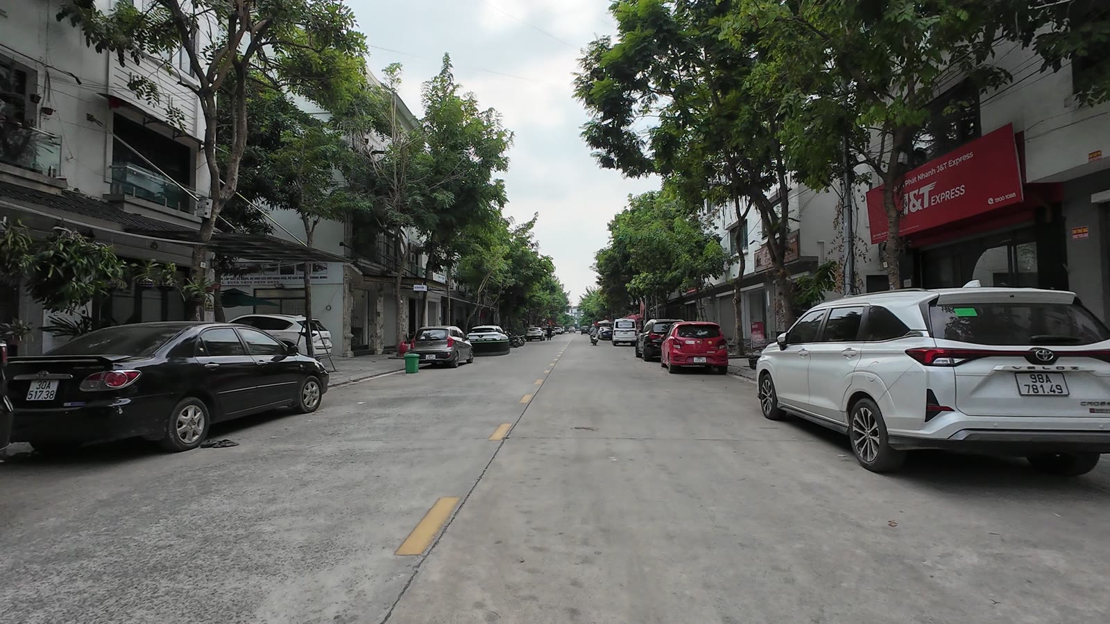 Phố Khu B Geleximco An Khánh, hai bên là nhà phố có biển văn phòng công ty, xe cộ thưa